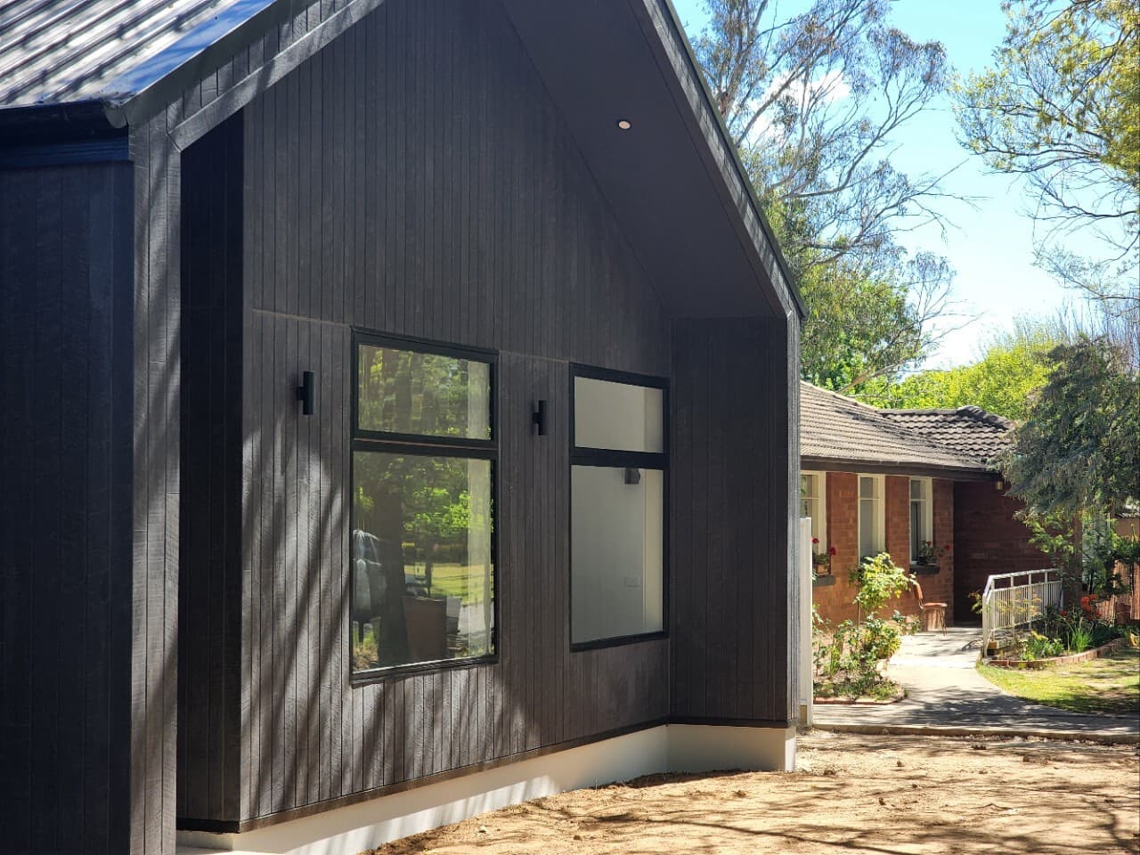 Modern new build in Canberra, Australia with dark timber cladding and large windows.